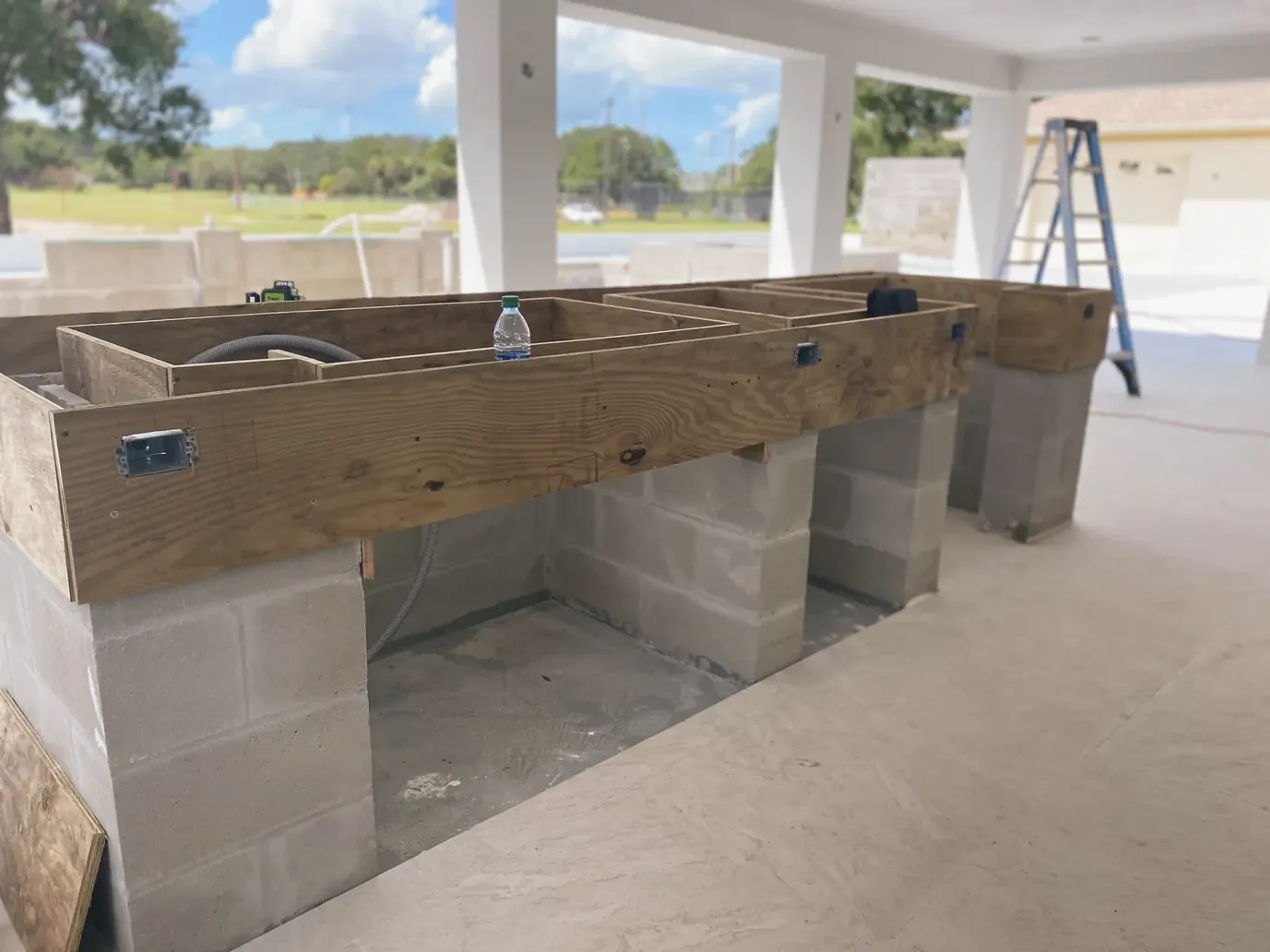 Outdoor kitchen island framing on concrete block under a covered lanai