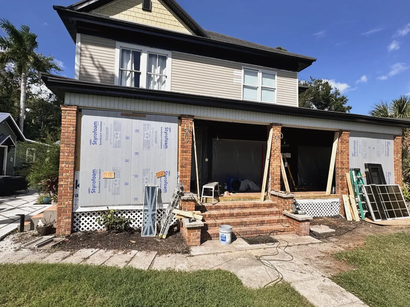 House exterior with new structural framing and wall wrap during renovation