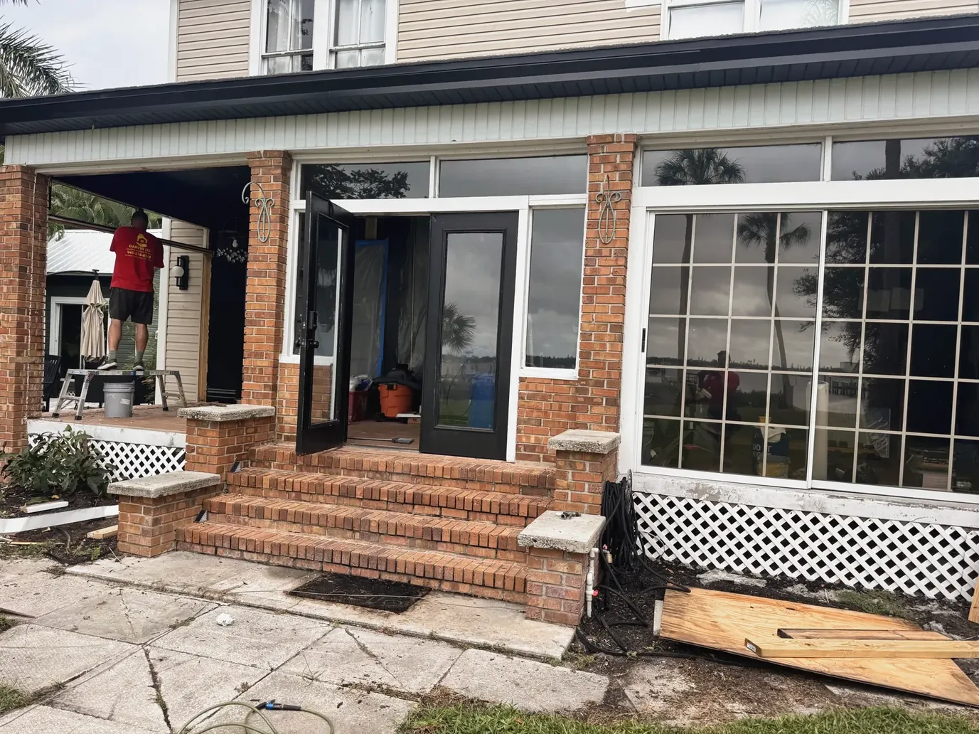 Brick entry steps and glass doors of a home during a porch renovation