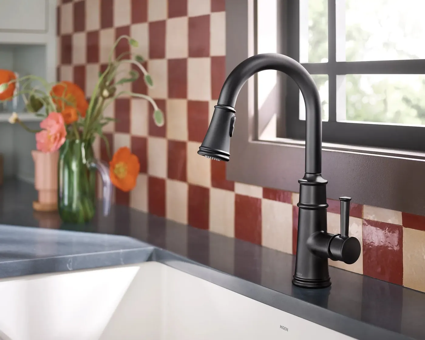 Matte black Moen Belfield faucet against red and cream checkered tile