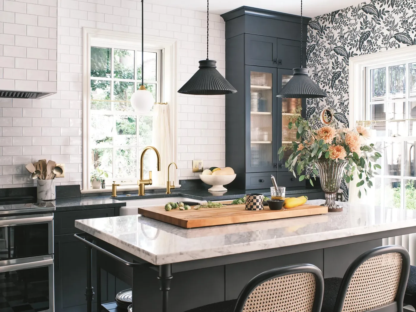 Gold Moen Cia faucet on an island in a kitchen with black pendants
